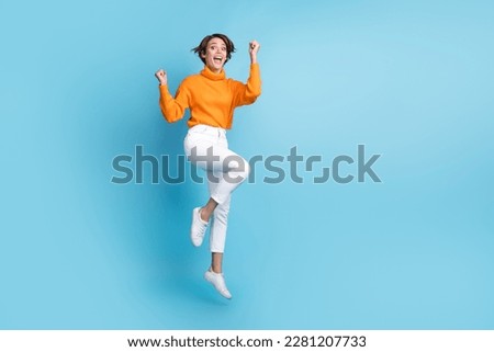 Full size photo of pretty young girl jump cheerful win lottery celebrate wear trendy orange outfit isolated on blue color background Royalty-Free Stock Photo #2281207733