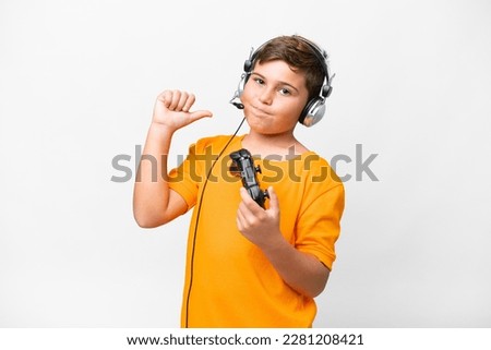 Little caucasian kid playing with a video game controller over isolated white background proud and self-satisfied