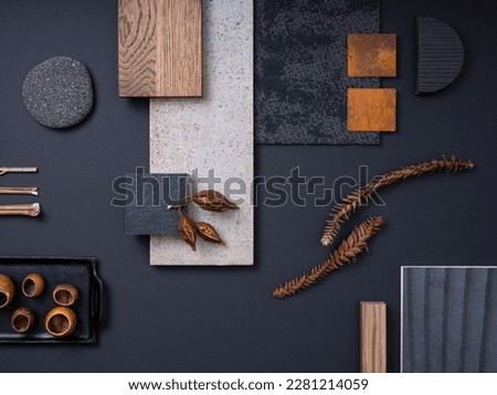 Aesthetic  flat lay composition in grey and navy color palette with textile and paint samples, lamella panels, leaves and tiles. Architect and interior designer moodboard. Top view. Copy space. 