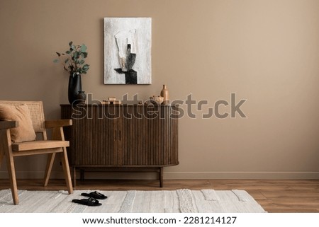 Creative composition of living room interior with mock up poster frame, copy space, wooden sideboard, vase with branch, rattan armchair, beige rug and personal accessories. Home decor. Template.  Royalty-Free Stock Photo #2281214127