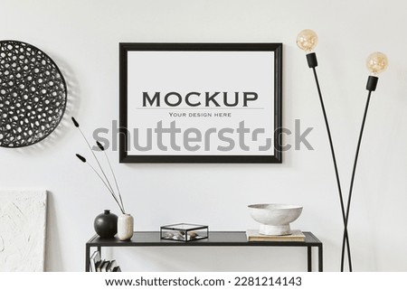Minimalistic stylish composition of creative room interior design with mock up poster frame, metal shelf, industrial lamp and personal accesories. Black and white concept. Template.