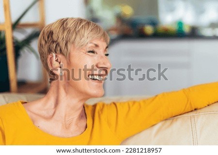 Mature woman with hearing aid indoors smiling Royalty-Free Stock Photo #2281218957