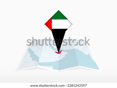 United Arab Emirates is depicted on a folded paper map and pinned location marker with flag of United Arab Emirates. Folded vector map. Royalty-Free Stock Photo #2281242597