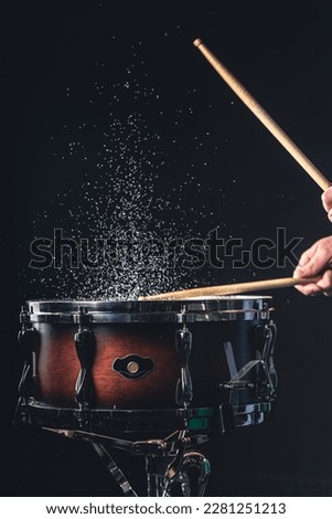 Drummer using drum sticks hitting snare drum with splashing water. Royalty-Free Stock Photo #2281251213