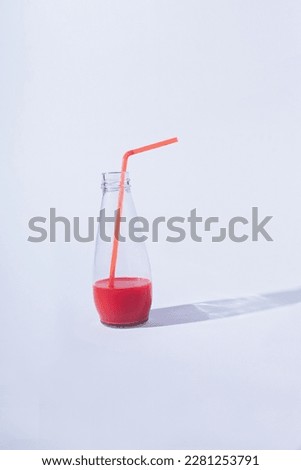 Fresh and natural red juice in a jar with straw on white background. Summer or refreshment concept idea.