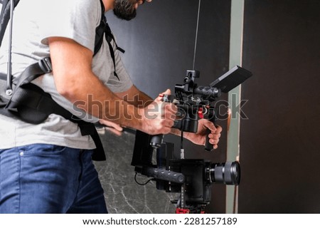 The cameraman in the studio using a professional camera with a stabilizer