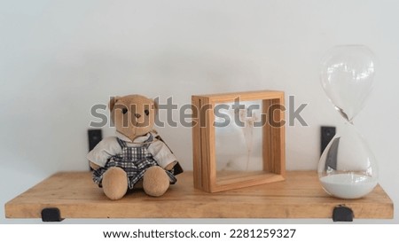 Teddy bears, picture frames and hourglasses on shelves.