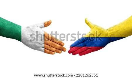 Handshake between Colombia and Ireland flags painted on hands, isolated transparent image.