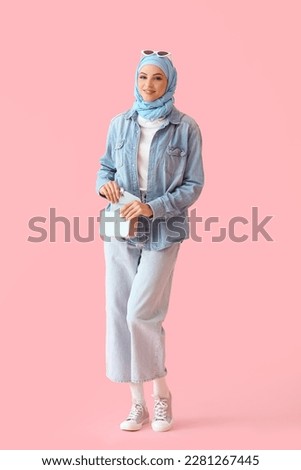 Stylish Muslim woman in blue hijab on pink background Royalty-Free Stock Photo #2281267445