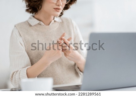 cropped view of teacher showing British two handed sign alphabet meaning letter f during online lesson