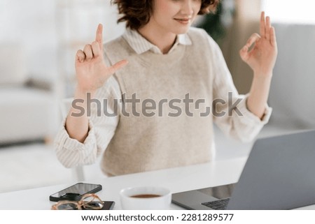 cropped view of sign language teacher showing alphabet signs during online lesson on laptop at home