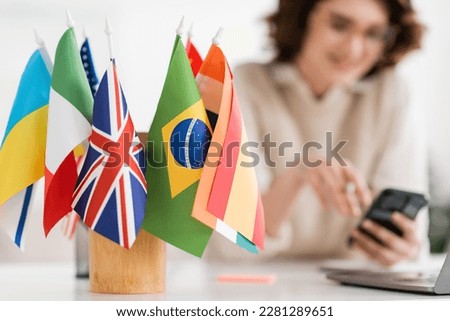 international flags of different countries near language teacher on blurred background