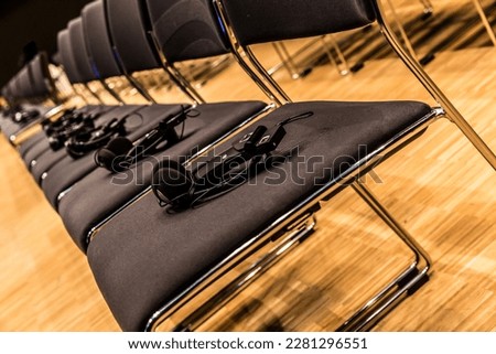 row of chairs with headphones in a conference hall