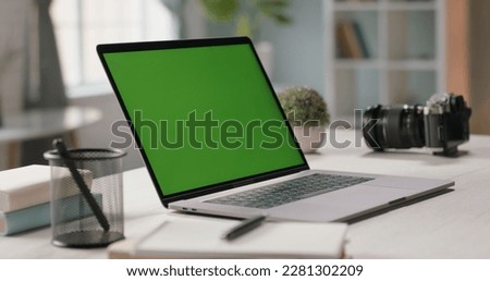 The table of distant worker at home. Modern laptop computer with chroma key green screen. Remote work, distance learning, technology concept close up 