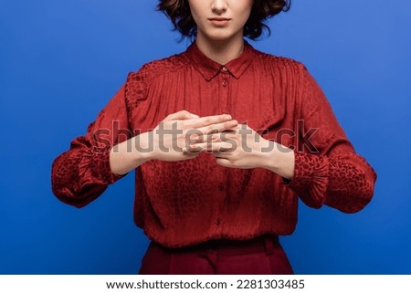 cropped view of teacher showing name word with hands while teaching how to use sign language isolated on blue