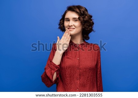 smiling teacher showing thank you gesture on sign language isolated on blue