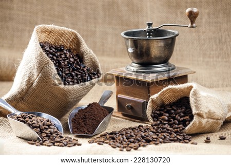 still life of coffee beans in jute bags with coffee grinder Royalty-Free Stock Photo #228130720