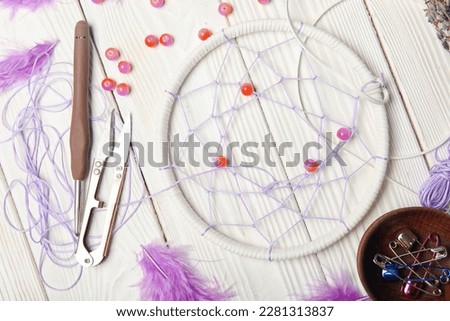 Materials for making dream catcher on white wooden background