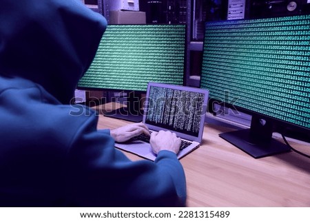 Hacker working with computers at wooden table indoors. Cyber attack