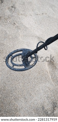A metal detector on a sea sandy beach. 
