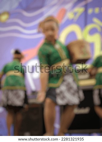 blurred background art performance performed by girl in green traditional dress blur