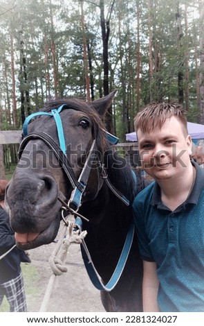 A guy and a horse.The horse shows his tongue.Funny picture.Animals are like people.