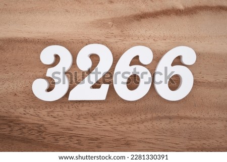 White number 3266 on a brown and light brown wooden background.