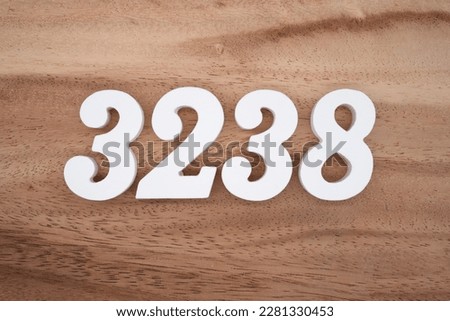 White number 3238 on a brown and light brown wooden background.