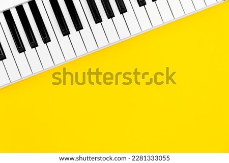 Piano keys on a yellow background, top view, flat lay, copy space.
