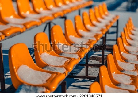 Stadium yellow chairs with white snow. Winter time.