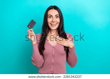 Photo of gorgeous girl straight hairdo pastel cardigan palm on chest hold credit card got salary isolated on vibrant teal color background