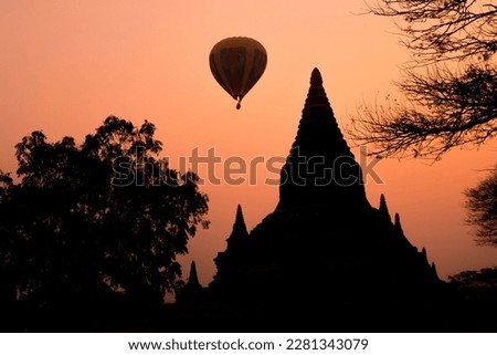 The temple in Bagan on sunset with the balloon in the orange sky