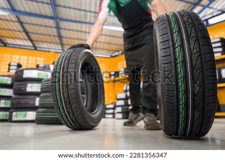 A tire changer checks new tires in stock to take them to a service center or wheel shop. Tire warehouse for the automobile industry