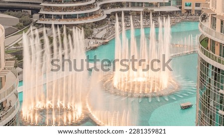 Dubai singing fountains with walking area around aerial . People watching show near shopping mall during sunset Royalty-Free Stock Photo #2281359821