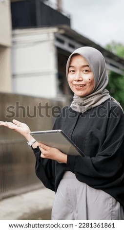Portrait of young hijab women using tablet in outdoor