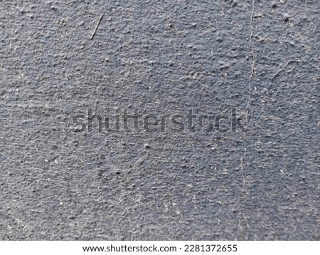 The texture of the cement wall painted with black paint and dust.