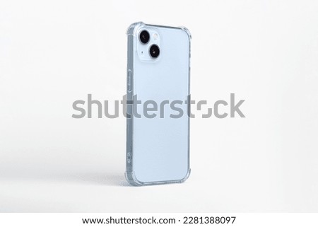 Phone case mock up side view. blue iPhone 14 plus in clear transparent soft silicone case isolated on gray background, rotated position. Smartphone perspective view