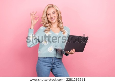 Photo of young lady curly hair wear cardigan daisy flower print show okey sign hold laptop new software isolated on pink color background