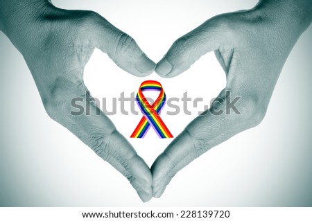 woman hands forming a heart ina black and white and a bright rainbow ribbon in the space  Royalty-Free Stock Photo #228139720