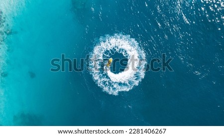 aerial top down drone image of Jet ski doing donuts. Blue ocean in maldives 