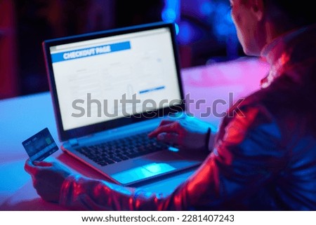 Seen from behind modern woman with laptop and credit card buying online.