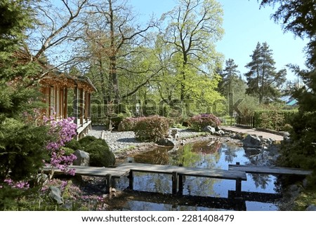 Japanese garden in the Botanical garden of St. Petersburg (Russia) on a sunny spring day. Bright beautiful landscape with traditional Japanese-style house and plants.