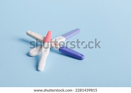 Pregnancy tests on blue background. Women's health, fertility, planning maternity and pregnancy concept. Stack of test kits with positive results. Copy advertising space