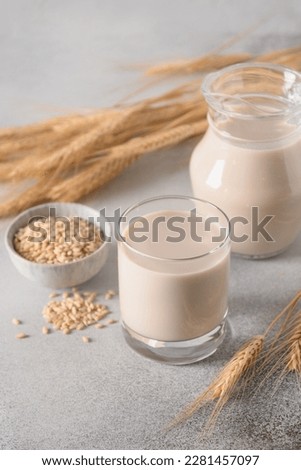 Barley milk on gray background. Alternative vegan plant based milk replacer and lactose free. Vertical format. Close up. Royalty-Free Stock Photo #2281457097