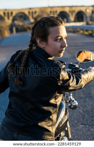 Biker woman with braids happy with her motorcycle