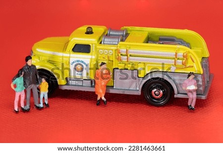 macro photography of green fire truck with small human figures