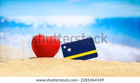 I love Curacao. Flag of Curacao on the beach with a red heart. vacation and travel concept. Royalty-Free Stock Photo #2281464149
