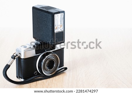 old roll system camera with antique flash on wooden table, photography theme, visual communication, top view, horizontal position