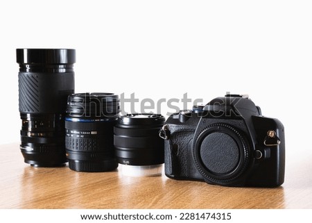 Photographic equipment kit, camera and photographic lenses lined up on wooden table, horizontal photography, photography theme, visual communication, side view Royalty-Free Stock Photo #2281474315