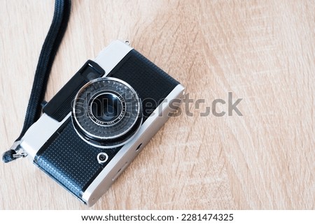 old photographic camera lying on wooden table, photographic roll system, photography theme, visual communication, top side view, horizontal position